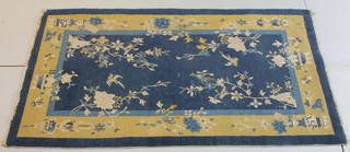 A 1930's Chinese blue and yellow ground rug decorated urns, lanterns and birds, 81" x 49"