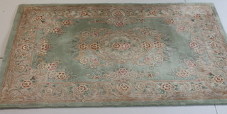 A Chinese green ground and floral pattern rug 76" x 60"