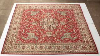 A machine made red ground Persian pattern rug 105" x 90"