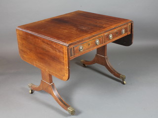 A late George III mahogany and parcel ebonised sofa table, cross  banded and boxwood line inlaid, fitted 2 short frieze drawers and  2 faux fronted opposing drawers, raised on splayed legs, brass  caps and casters 28.5"h x 56"w x 30"d