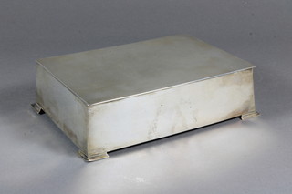 An Art Deco rectangular waisted silver cigarette box with with  hinged lid and bracket feet, Birmingham 1935 6.5"
