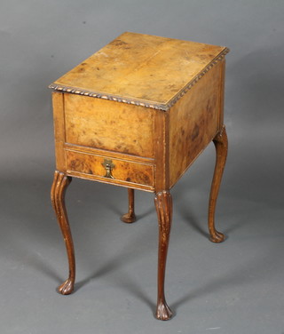 A 1930's burr walnut work table, the hinged lid enclosing a silk lined interior above a side drawer, raised on cabriole legs pad  feet 25"h x 18"w x 13"d