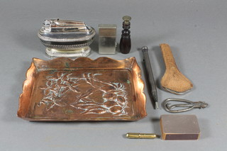 An oval silver table lighter with demi-reeded decoration, a bottle opener, seal, rectangular embossed copper tray and other curios