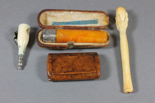 A carved ivory cigarette holder in the form of a claw, a horn and silver plated cigar cutter in the form of a bottle of Bollinger champagne, a cigar holder and a walnut snuff box