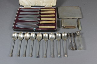 A silver cigarette case with engine turned decoration, a silver match box, 9 silver seal end teaspoons, 11 ozs, together with a  set of 6 silver tea knives, folding fruit knife with silver blade and  mother of pearl mounts, a pair of tongs and a glass scent phial  with silver lid