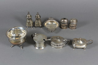 A silver sugar bowl raised on hoof feet, a silver tea strainer, a 3 piece silver condiment set 9ozs, together with a 3 piece silver  condiment set with blue glass liners