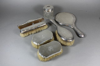 A pair of military style silver backed hair brushes, London 1940,  a hobnail cut hair tidy with silver lid, a silver backed hand  mirror, hair brush, clothes brush and comb