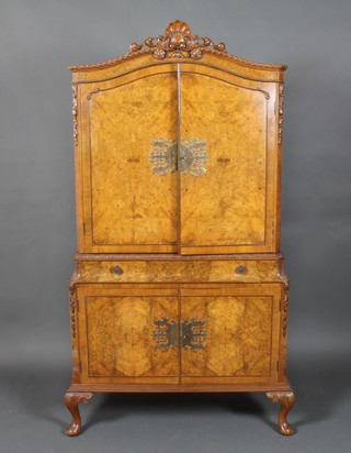 A Queen Anne style figured walnut cocktail cabinet with arched top, enclosed by a pair of panelled doors, the base fitted 1 long  drawer above a double cupboard, raised on cabriole supports  68"h x 35"w x 15"d