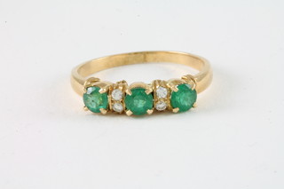 An 18ct gold half hoop dress ring set emeralds