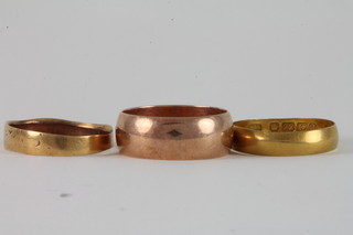 A 22ct gold wedding band 2.7 grams, a 9ct gold wedding band  5.0 grams and a yellow metal band