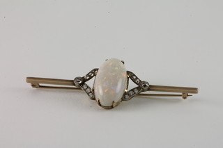 A gold bar brooch set an oval opal surrounded by white stones