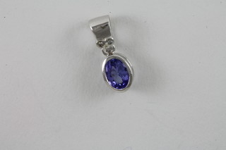 A 9ct gold white gold pendant set an oval cut topaz surrounded  by diamonds