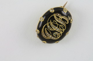 A gold and enamelled diamond set mourning brooch