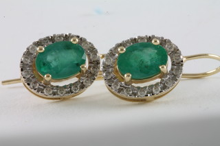 A pair of 14ct gold cluster earrings set emeralds and diamonds