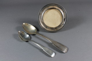 A Victorian silver fiddle pattern table spoon, Newcastle, a Georgian silver fiddle pattern teaspoon and a circular silver easel  photograph frame 4"