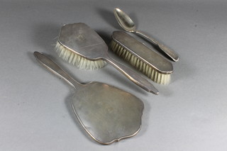A silver fiddle and thread patterned spoon and a 3 piece silver backed dressing table set
