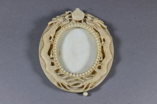 A Chinese oval carved ivory photograph frame decorated dragons  4"