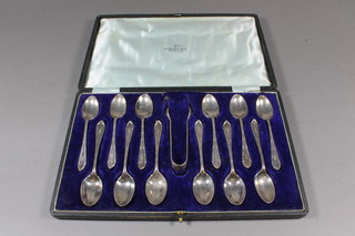 A set of 12 silver coffee spoons Sheffield 1916 by Walker & Hall and a pair of silver sugar tongs Sheffield 1902 5 ozs