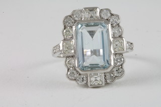 An 18ct white gold dress ring set a rectangular cut aquamarine surrounded by diamonds