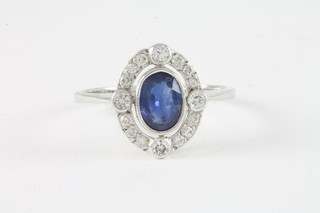 An 18ct white gold dress ring set an oval sapphire surrounded by diamonds approx 0.95ct/0.30ct