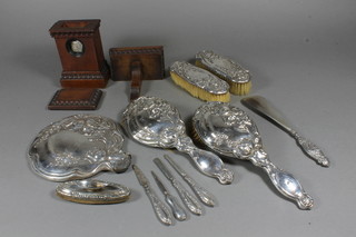 A 6 piece silver backed dressing table set comprising and 5 silver handled manicure implements and a 1950's Unicorn wristwatch  contained in a wooden case with bracket