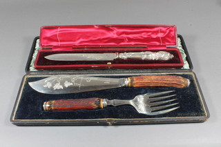 A pair of silver plated fish servers with stag horn handles and a  cake knife with silver plated handle, cased