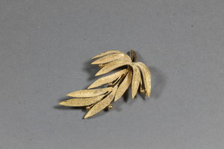 A yellow metal spray brooch