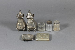 A pair of silver pepperettes, a silver vesta case, a plated vesta  case and a 3 piece miniature glass condiment set