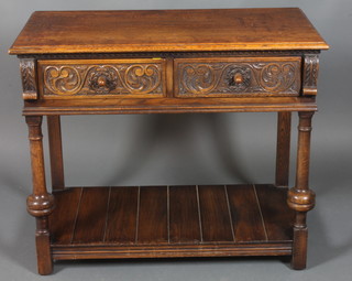 A carved oak side table fitted 2 long drawers, raised on turned supports with pot board 30"h x 36"w x 18"d