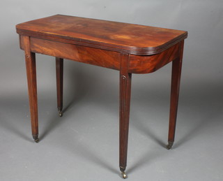 A Georgian mahogany D shaped tea table raised on fluted  supports ending in brass caps and casters 29"h x 36"w x 17.5"d