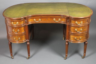 An Edwardian mahogany kidney shaped writing table with green skiver, fitted 1 long and 6 short drawers, raised on turned and  fluted legs 30"h x 55"w x 28"d  ILLUSTRATED