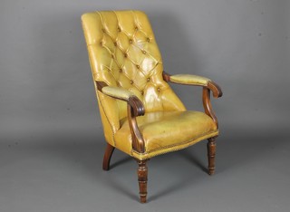 A William IV mahogany open arm chair upholstered in green buttoned leather