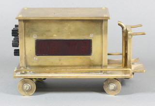 An electric digital clock in the form of a brass electric trolley