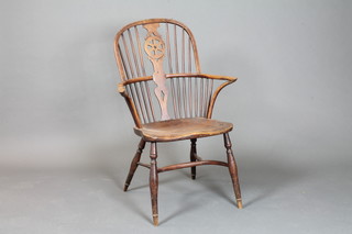 An 18th Century yew and elm stick and rail Windsor kitchen  chair with solid elm seat, crinoline stretcher on turned supports