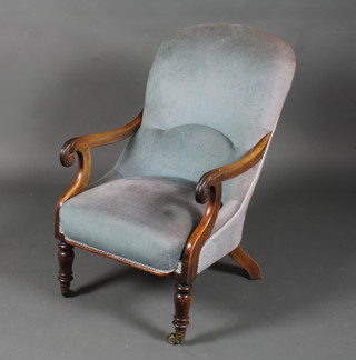 A William IV mahogany show frame open arm chair upholstered  in blue material, raised on turned legs ending in caps and casters