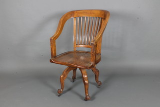 A Victorian oak tub back revolving office chair on cabriole  supports