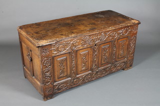 A mid 17th Century oak coffer of panelled construction having a solid hinged top enclosing 2 candle boxes, the frieze of 4 fielded  panels, relief carved with flowers, raised on end stiles, 25"h x  50"w x 22"d