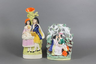 A Staffordshire arbour group of a seated lady and gentleman 8"  and a reproduction Staffordshire flatback figure group of a  standing lady and gent 11.5"