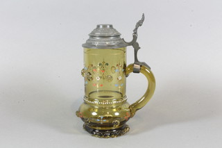 A brown glass Stein with pewter lid and enamelled decoration,  raised on a circular foot 8", chip to base