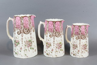 A set of 3 Victorian graduated pottery jugs with puce and gilt banding