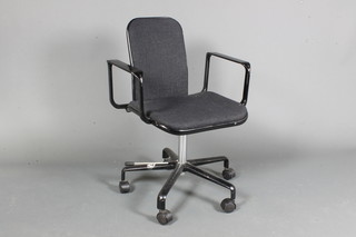 Fred Scott for Hille International, a late 1970's swivel desk elbow chair, having black frame and dark grey woven  upholstery, raised on casters, a.f.