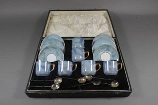 A German porcelain 12 piece blue lustre tea service comprising  6 cups and 6 saucers - 1 cup handle f, together with 6 silver bean  end coffee spoons