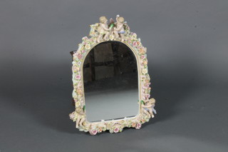 An arched bevelled plate mirror contained in a Renaissance style  frame decorated cherubs and flowers 17" x 14"
