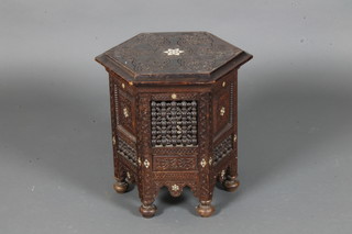 An octagonal carved Moorish folding occasional table raised on bun feet 16"h x 16"diam.