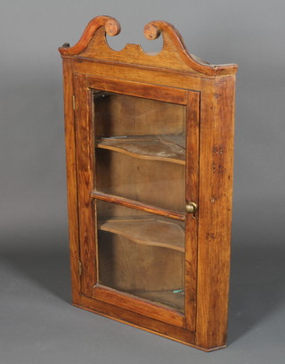 A late George I pine and oak hanging corner cupboard with  broken swan neck pediment above a glazed door enclosing 2  shaped shelves, 42"h x 27"w x 13"d