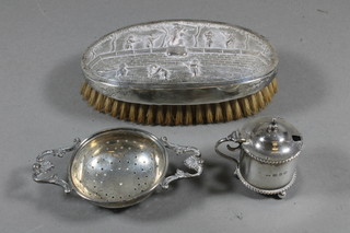 A silver tea strainer 1925, a circular silver salt Birmingham  1924, together with an oval Eastern embossed silver military hair  brush
