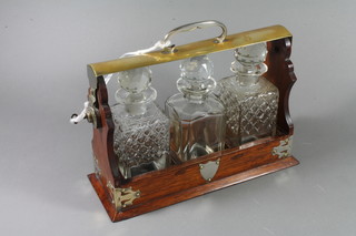 An American silver plated tantalus fitted 3 bottles