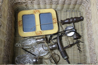 A wicker box containing 2 19th Century steel corkscrews and a collection of old spectacles