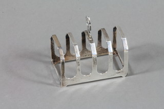 A silver 5 bar toast rack, London 1934 with Jubilee hallmark 2 ozs together with a 2 piece silver backed dressing table set 