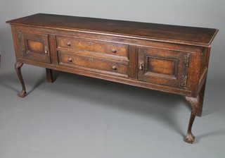 A Georgian style oak dresser base with 2 centre drawers flanked by cupboard doors on carved cabriole legs with claw and ball feet 31" x 72" x 18"